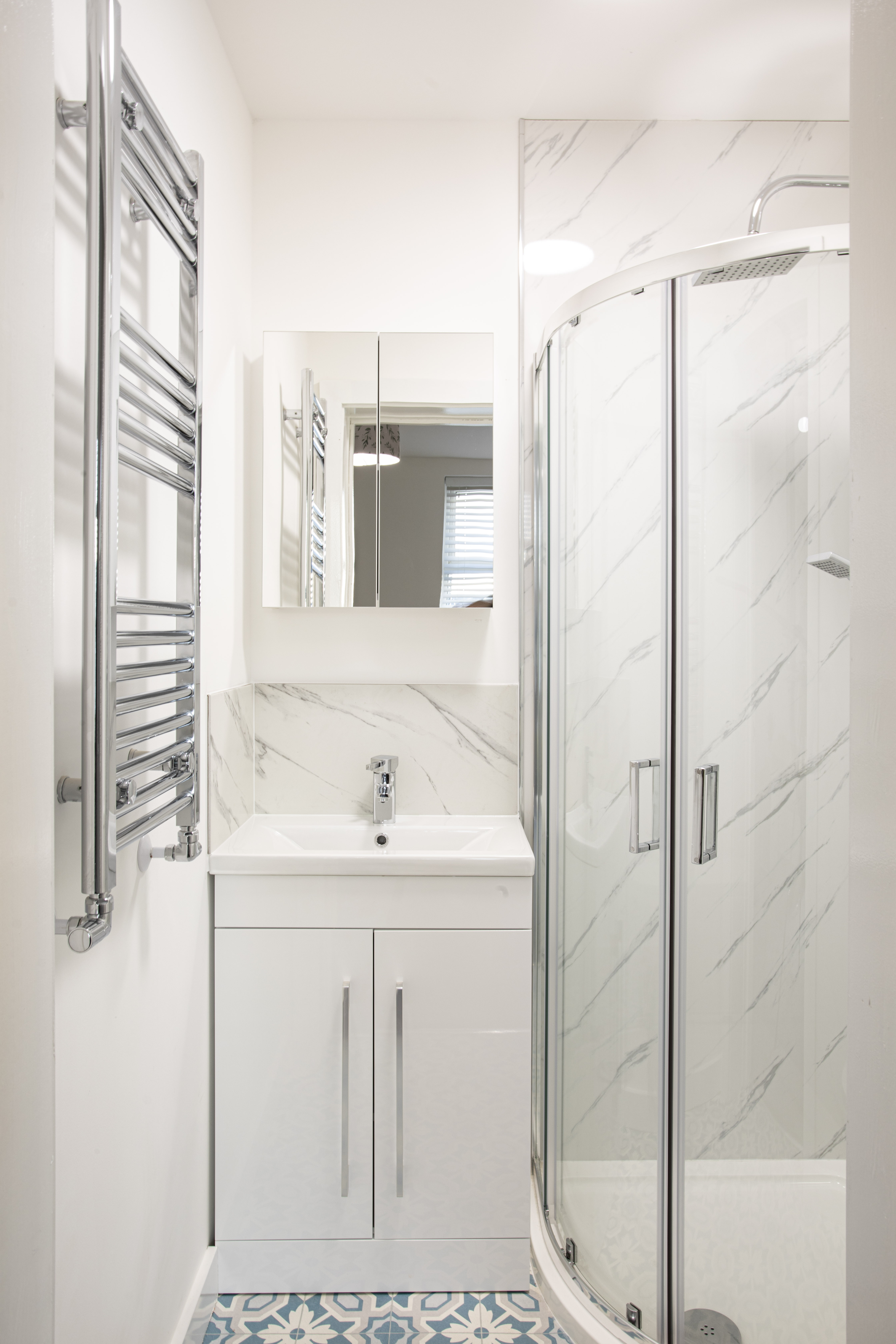 New en-suite shower room with marble-effect tiles and heated towel rail