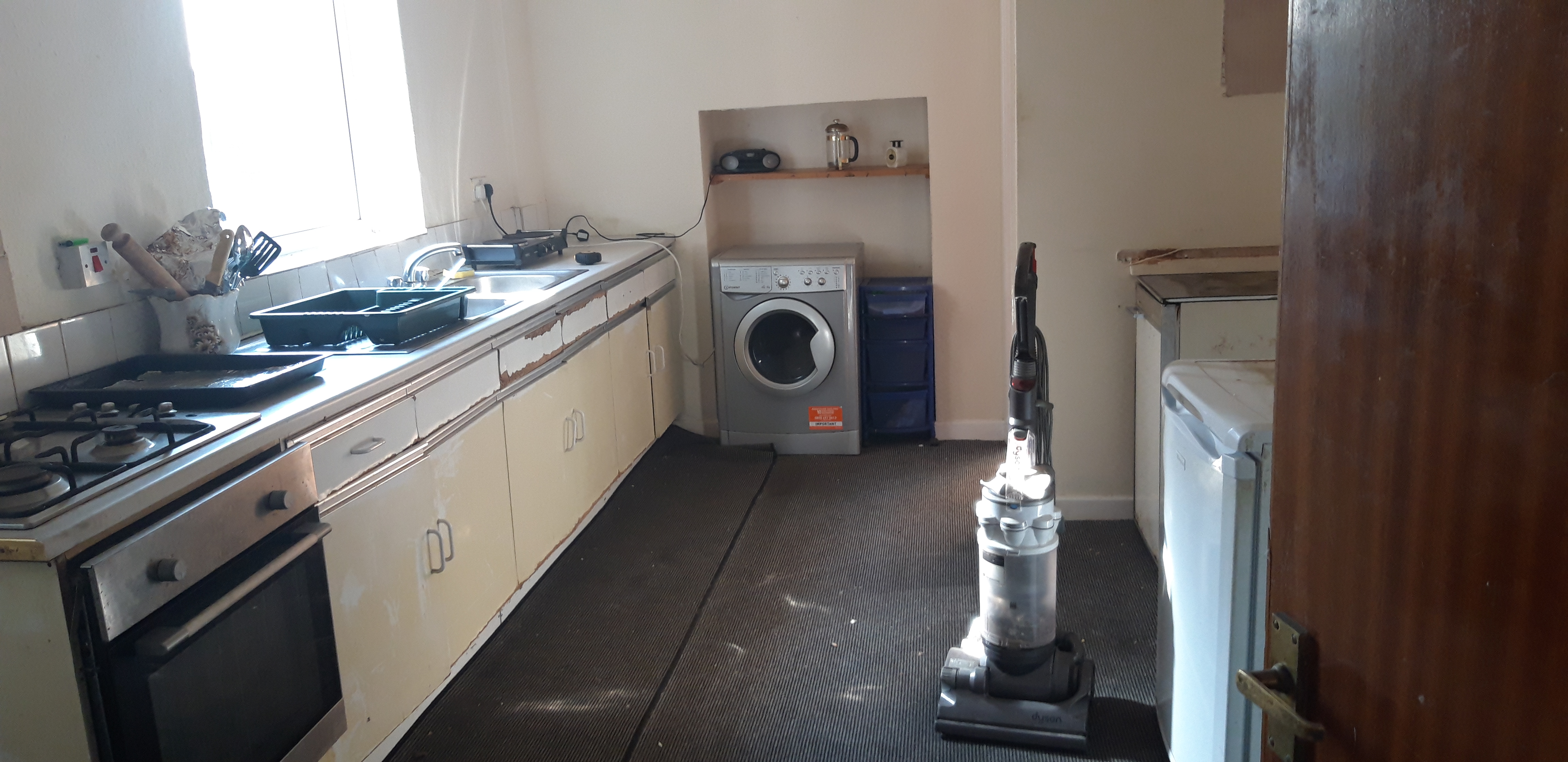 Dated communal kitchen in poor condition — original state at purchase